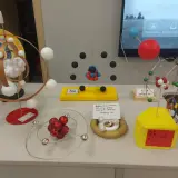 Modele atomów wykonane z różnych materiałów, w tym kulek, drutu i pianki.