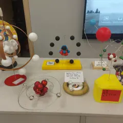 Modele atomów wykonane z różnych materiałów, w tym kulek, drutu i pianki.