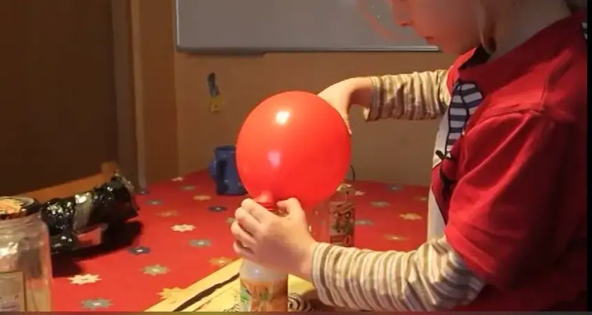 dziecko pompuje balonik proszkiem do pieczenia i octem